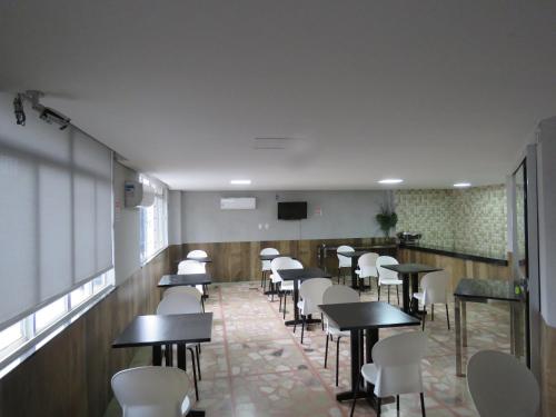 蓬蒂诺瓦Hotel Picpo的带桌子和白色椅子的餐厅