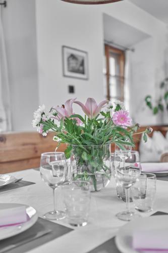 a table with a vase of flowers and glasses on it at Marbergerhaus Umhausen in Umhausen