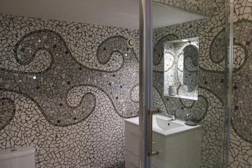 un bagno con doccia, lavandino e specchio di Auberge des Chevaliers a Canlers