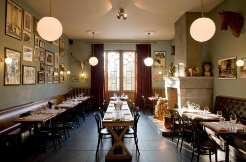 uma sala de jantar com mesas e cadeiras e uma lareira em PRET A GOUTER bistro bar bed em Heusden - Zolder