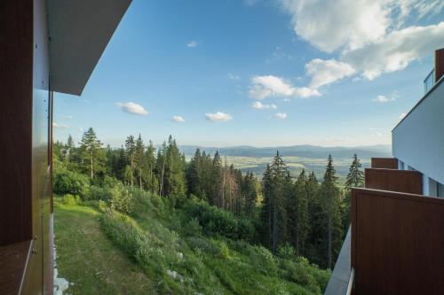 a view from a window of a hill with trees at Apartmany Panorama 10X-90X in Štrbské Pleso