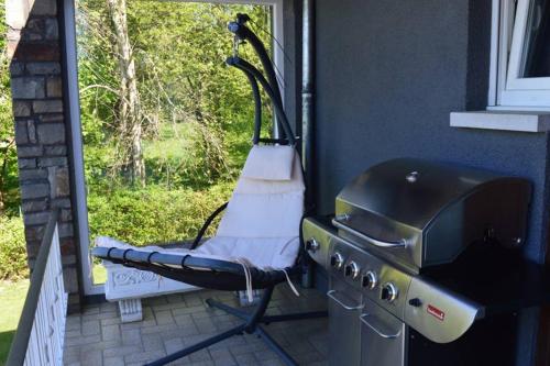a grill on a porch next to a window at Maison de vacances privative à louer in Aywaille
