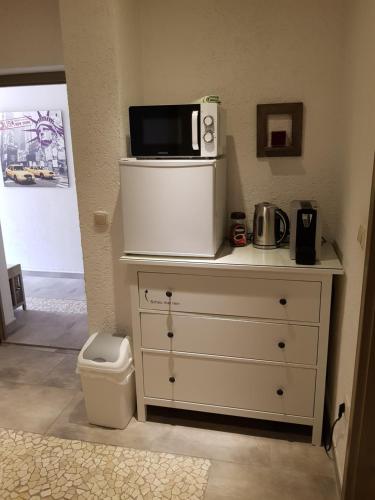 a white dresser with a microwave on top of it at Gäste Apartement Casa Luber in Thalmassing