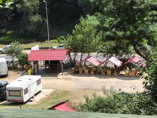 a group of tents in a parking lot with a trailer at CABANUTE si CAMPING DRACULA in Căpăţîneni-Pămînteni