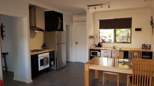 a kitchen with a table and a dining room at Red Ochre - Large Apartment with Private Courtyard in Port Pirie