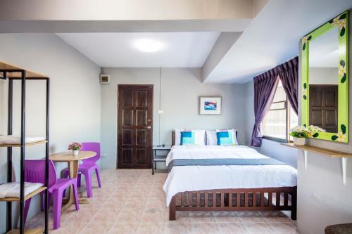 1 dormitorio con 1 cama, mesa y sillas en Penyos Mansion (Long Stay) en Bangkok