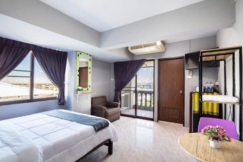 a bedroom with a bed and a couch and a table at Penyos Mansion (Long Stay) in Bangkok