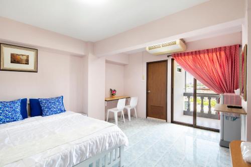 a bedroom with a bed and a desk and a window at Penyos Mansion (Long Stay) in Bangkok