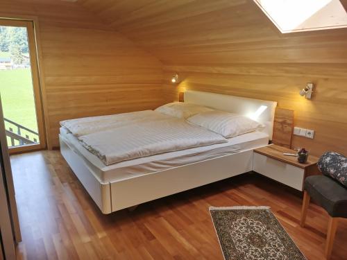 a bed in a room with a wooden ceiling at Ferienwohnung auf der Scheibe in Bezau