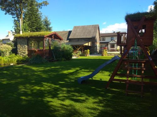 un parque infantil en un patio con tobogán en Pokoje Gościnne Jurgowianka en Jurgów