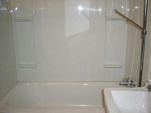 a bathroom with a white bath tub next to a sink at Holiday Cottage in Canora