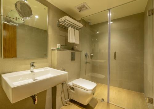 a bathroom with a sink and a toilet and a shower at Quality Inn Ramachandra in Visakhapatnam