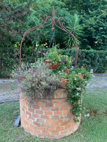 a brick planter with flowers and plants in it at Il Pozzetto Home Resort in Pietrasanta