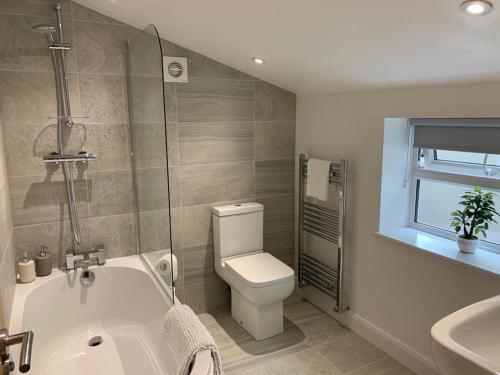 uma casa de banho com uma banheira, um WC e um lavatório. em CAERNARFON Quality Townhouse em Caernarfon