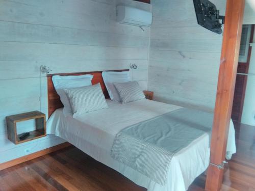 un lit blanc avec une tête de lit en bois et une horloge dans l'établissement Quenetier, à Saint-François