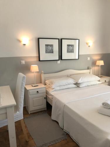 a bedroom with two beds and a desk and two lamps at Paradisos in Áyioi Pándes