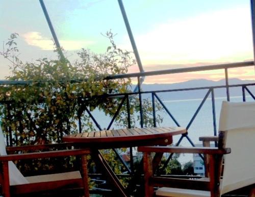 a table and chairs on a balcony with a view of the ocean at Nefeli Studios in Loutra Edipsou