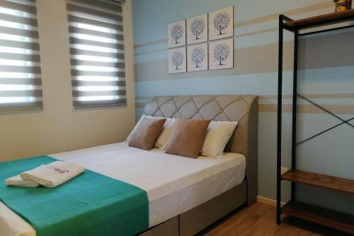 1 dormitorio con 1 cama con sábanas y almohadas blancas en Seri Gandaria Homestay @ Bandar Baru Bangi, en Kampong Sungai Ramal Dalam