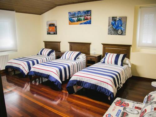3 camas en una habitación con suelo de madera en Antonio de Sofia, en César