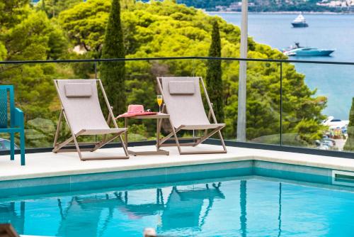 a pair of chairs sitting next to a swimming pool at Hotel Seventh in Cavtat