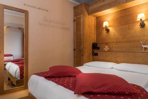a bedroom with two beds and a mirror at Locanda Bellevue in Pré-Saint-Didier