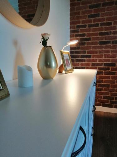 a table with a vase and a picture and a lamp at Apartament Claudia -self check-in in Brăila