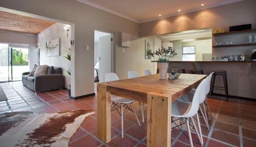 a kitchen and living room with a wooden table and chairs at Rest at Chabivin in Stellenbosch