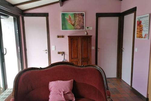 a living room with a couch in a room with pink walls at Sprookjesachtig verblijven in Sunparks Oostduinkerke in Oostduinkerke