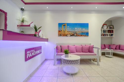 a living room with a pink couch and a table at Panormos Hotel and Studios in Naxos Chora