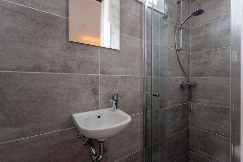 a bathroom with a sink and a shower at Studio Baarn with patio, airco, pantry, bedroom, bathroom, privacy - Amsterdam, Utrecht in Baarn