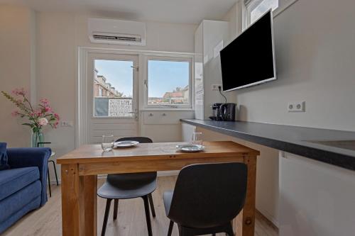 ein kleines Wohnzimmer mit einem Tisch und Stühlen in der Unterkunft Studio Baarn with patio, airco, pantry, bedroom, bathroom, privacy - Amsterdam, Utrecht in Baarn