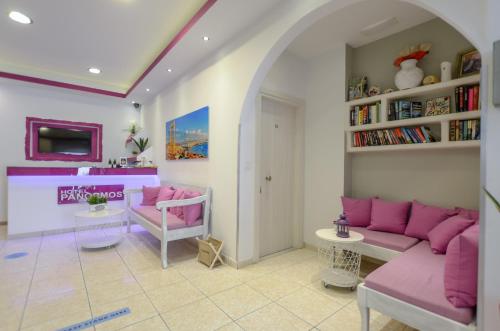 a living room with pink furniture and a book shelf at Panormos Hotel and Studios in Naxos Chora