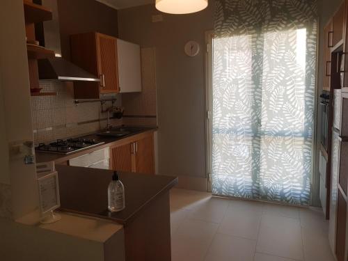 a kitchen with a window and a sink and a stove at CASA DI MIMMA casa vacanze in Reggio Calabria