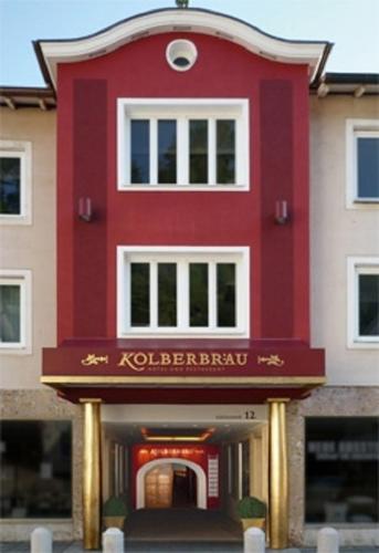 a red building with a sign in front of it at Posthotel Kolberbräu in Bad Tölz