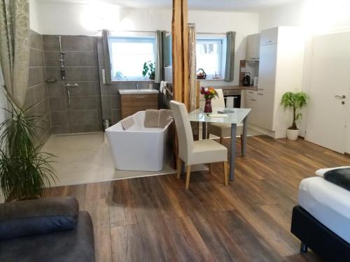 a bathroom with a tub and a table and a shower at Apartment Riedhof in Fahrenbach