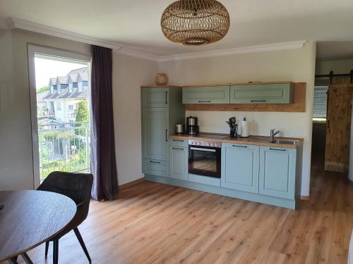 a kitchen with blue cabinets and a wooden floor at Moselfeeling co2frei in Cochem