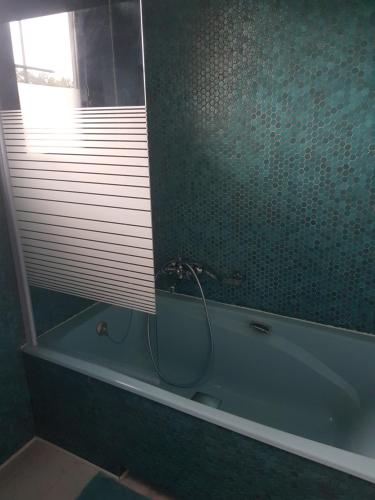 y baño con bañera, ventana y ducha. en Orée du Bois en Abreschviller