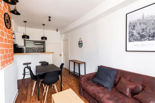 un salon avec un canapé et une table dans l'établissement Au Manhattan, à Auxerre