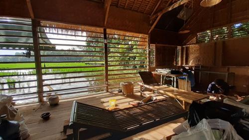 a living room with a large window and a table at d'Jarwo House in Batukaras