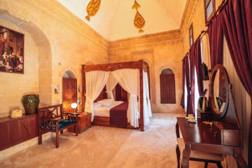 a bedroom with a bed and a dresser and a desk at Maristan Tarihi Konak in Mardin