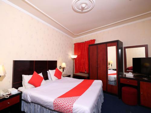 OYO 112 Semiramis Hotel في المنامة: غرفه فندقيه سرير كبير وتلفزيون