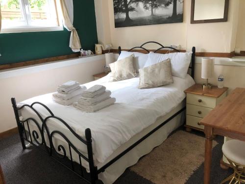1 dormitorio con 1 cama con toallas en Le Grand Camelia, en Saint-Martin-dʼAubigny