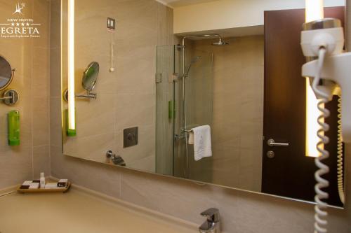 a bathroom with a shower and a large mirror at New Egreta Resort in Dunavăţu de Jos