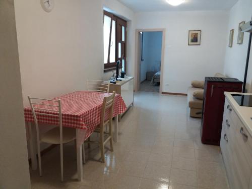 a kitchen and dining room with a table and chairs at Appartamento Garda Dolomiti crocevia tra laghi e montagne in Comano Terme