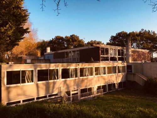 un ancien bâtiment avec des fenêtres dans un champ dans l'établissement Auberge de Jeunesse HI Lorient, à Lorient