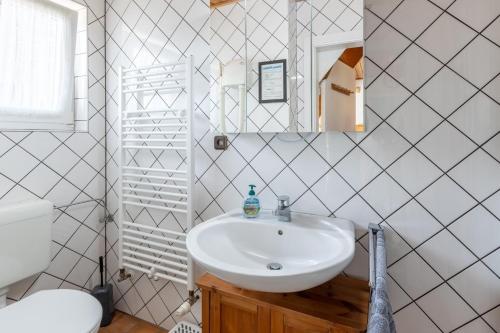 ein weißes Badezimmer mit einem Waschbecken und einem Spiegel in der Unterkunft Hack's Hus in Büsum