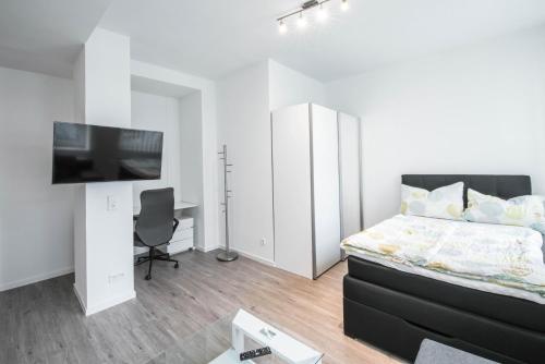 a bedroom with a bed and a flat screen tv at Central Apartments Aalen in Aalen