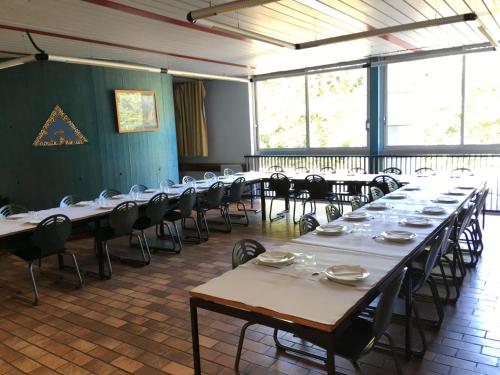 Auberge de Jeunesse HI Lorient في لوريان: غرفة كبيرة بها طاولات وكراسي ونوافذ