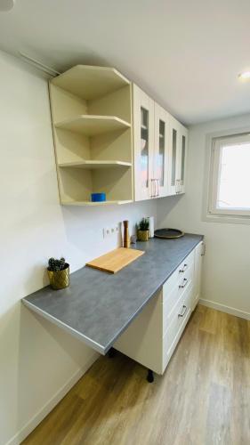 une cuisine avec des armoires blanches et un comptoir dans l'établissement Neuf et cosy à Barr, route des vins, à Barr