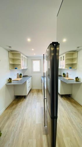 Il comprend une grande cuisine équipée d'un réfrigérateur noir. dans l'établissement Neuf et cosy à Barr, route des vins, à Barr